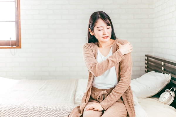 肩の痛みを感じる女性