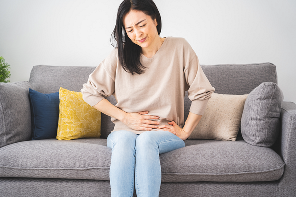 胃に痛みを感じる女性