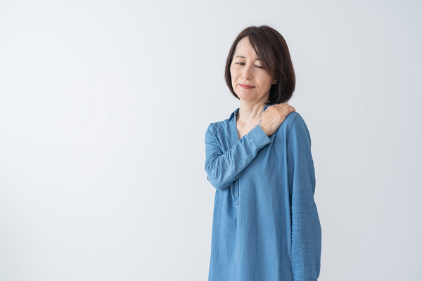 肩を触る女性